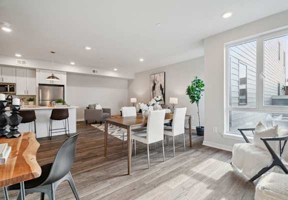 a living room and dining room with a table and chairs
