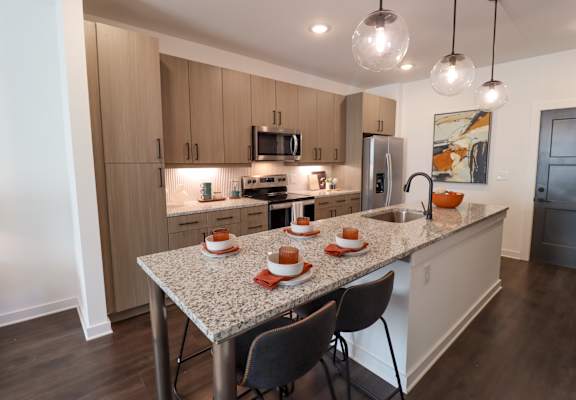 A kitchen with a table set for four. at The Wren Apartments, Lawrenceville, 30043