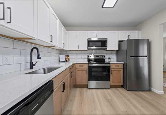 A kitchen with a black dishwasher and stove top oven.