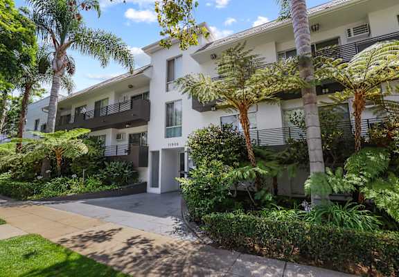 a view of the apartment building from the sidewalk