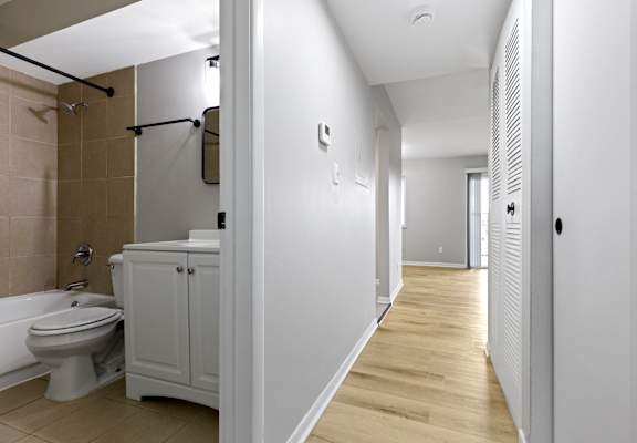 A white bathroom with a toilet, sink, and bathtub.