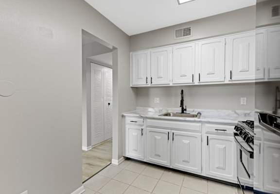 A kitchen with white cabinets and appliances.