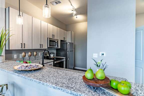 A modern kitchen with a black stove and white cabinets.