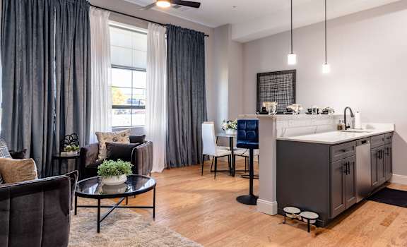 A modern kitchen with a dining area and a living room.