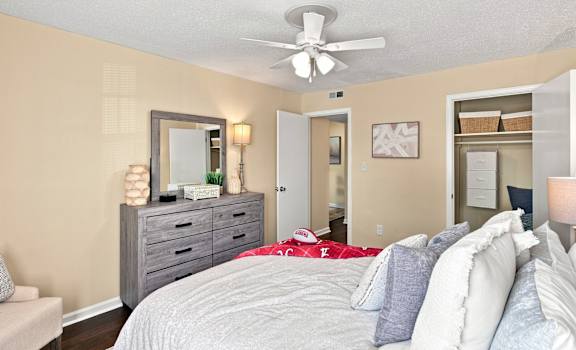 A bedroom with a bed, dresser, and mirror.