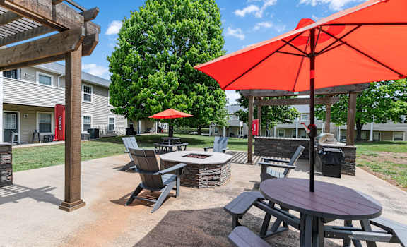 a patio with tables and chairs and umbrellas