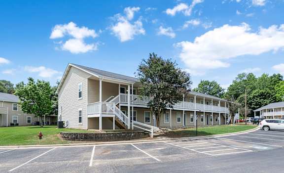 our apartments are located in a large parking lot next to a tree