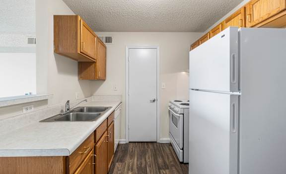 a kitchen with white appliances and wooden cabinets
