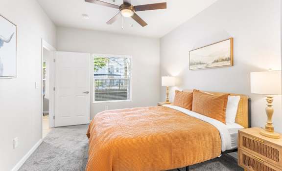 a bedroom with an orange bed and a ceiling fan