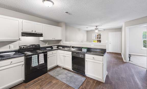 a kitchen with white cabinets and black appliances