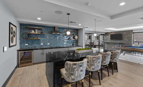 A modern kitchen with a black countertop and a dining table with chairs.