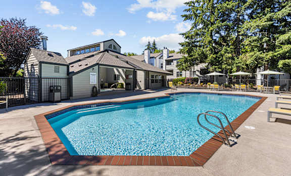 A swimming pool in front of a house.