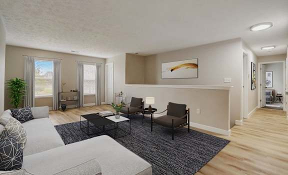 the living room of an apartment with a couch and chairs