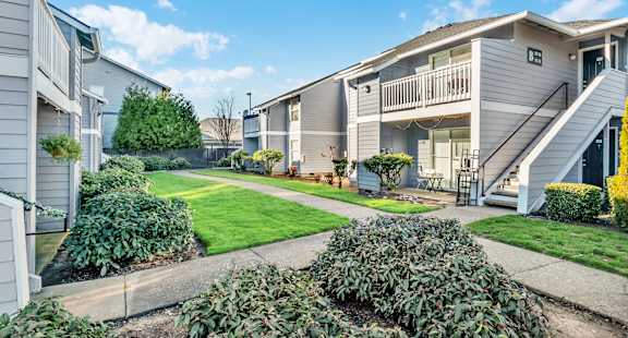 A sunny day at a residential area with houses and greenery.