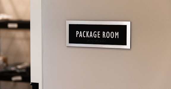 A sign that says "Package Room" is on a wall.