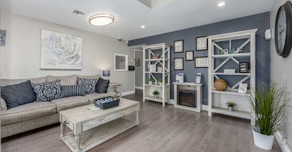 A living room with a grey couch and a wooden coffee table.