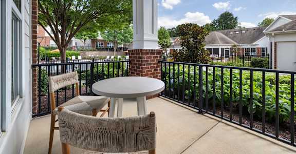 a patio with two chairs and a table on a balcony