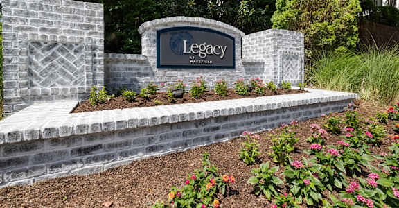 a sign for legacy at the entrance of a garden