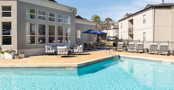 our apartments have a swimming pool with chairs and umbrellas at WildForest Apartments, Alabama