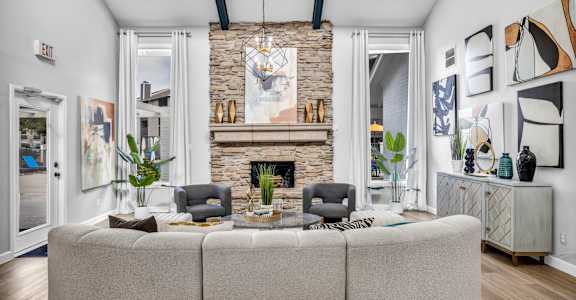 a living room with a large couch and a stone fireplace