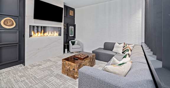 a living room with a gray couch and a fireplace
