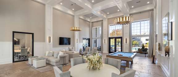 a living room with a round table and a pool table
