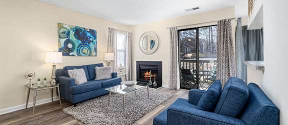 a living room with two blue couches and a fireplace