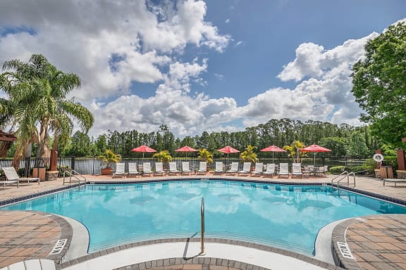 a resort style pool with lounge chairs and umbrellas at Northlake Park, 32827