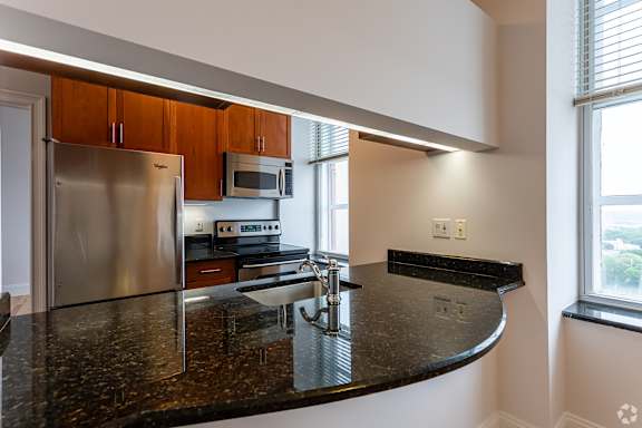 A kitchen with a granite counter top and stainless steel appliances.