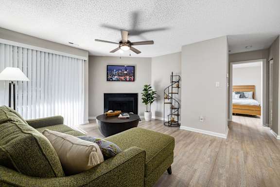 A living room with a green couch and a fireplace.