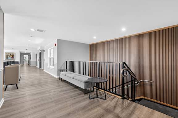 A long hallway with a bench and a table.