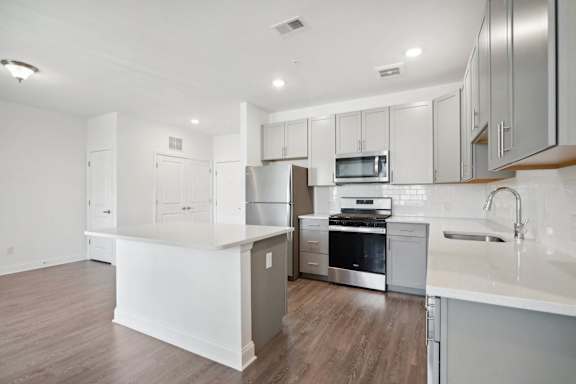 A modern kitchen with stainless steel appliances and white cabinetry.