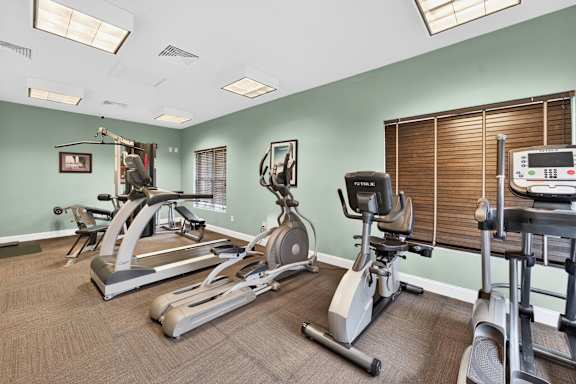 A gym with treadmills, exercise bikes, and elliptical machines.