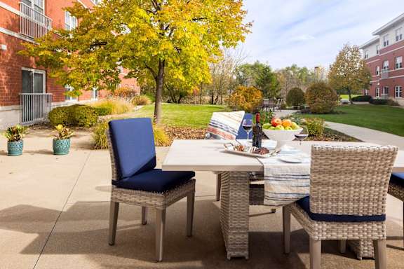 A table with chairs and a placemat is set for an outdoor meal.