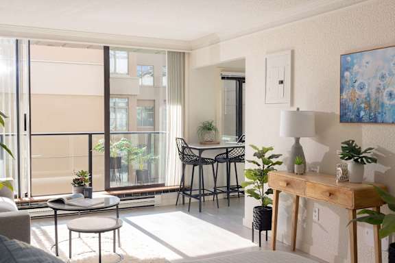 a living room with a table and chairs and a balcony