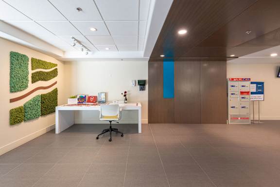 a workspace with a desk and a chair in a room with a wall with artwork