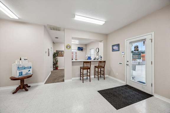 A room with a white box on a table and a black mat on the floor.