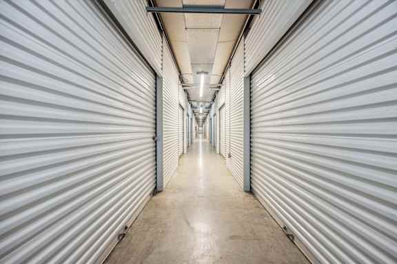 A long, narrow hallway with a series of doors on either side.