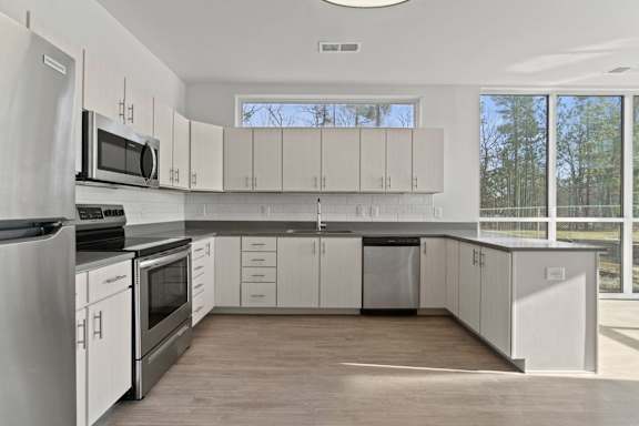 a kitchen with white cabinets and stainless steel appliances