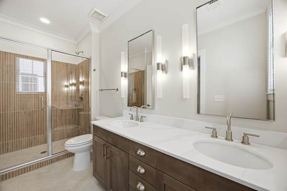 A bathroom with a toilet, sink, and mirror.