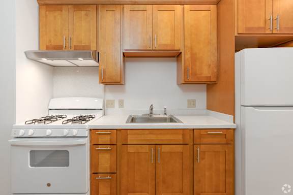 a kitchen with white appliances and wooden cabinets