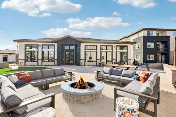 A modern outdoor seating area with a fire pit in the center.