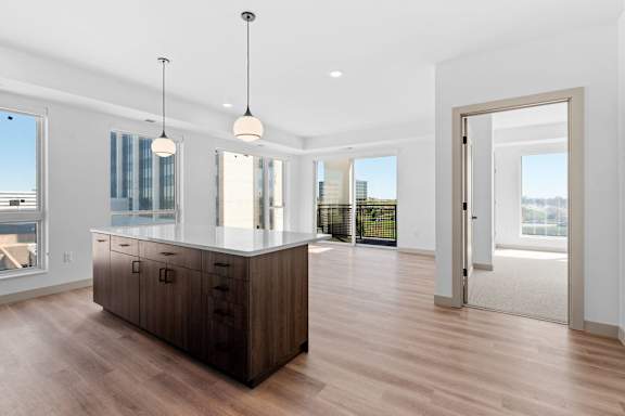 an open kitchen and living room with a large island at The Mera, St Louis Park, 55426