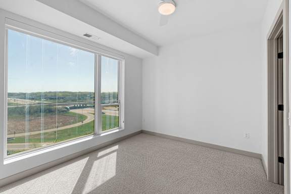 a living room with a large window and a view of a race track at The Mera, Minnesota