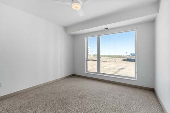 an empty room with a large window and carpeting at The Mera, Minnesota, 55426