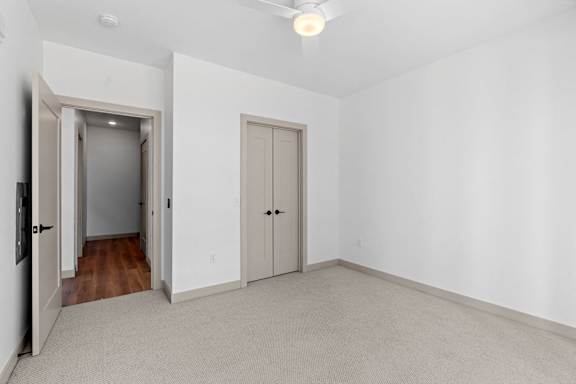 a living room with white walls and a door to a hallway at The Mera, Minnesota, 55426
