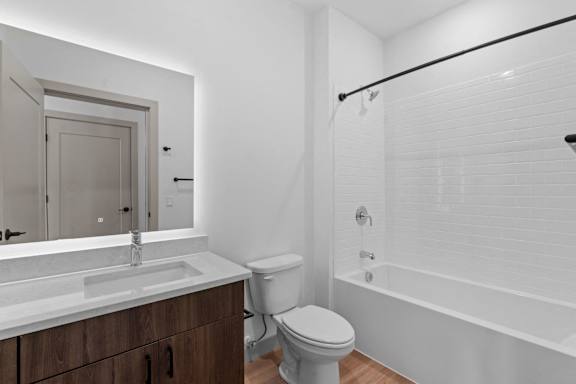 a bathroom with a toilet sink and shower and a mirror at The Mera, Minnesota, 55426