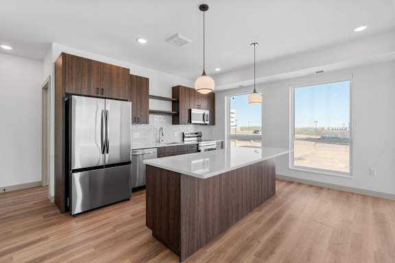 a kitchen with a large island and stainless steel appliances at The Mera, St Louis Park, 55426