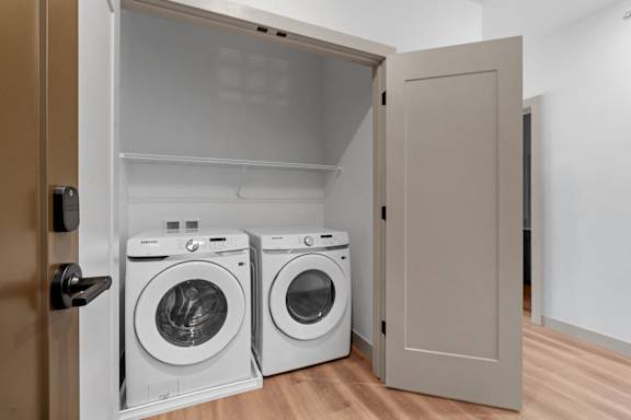 a washer and dryer in a laundry room with a closet at The Mera, St Louis Park, MN 55426