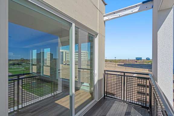 a balcony with a view of a city and a blue sky at The Mera, St Louis Park, MN 55426